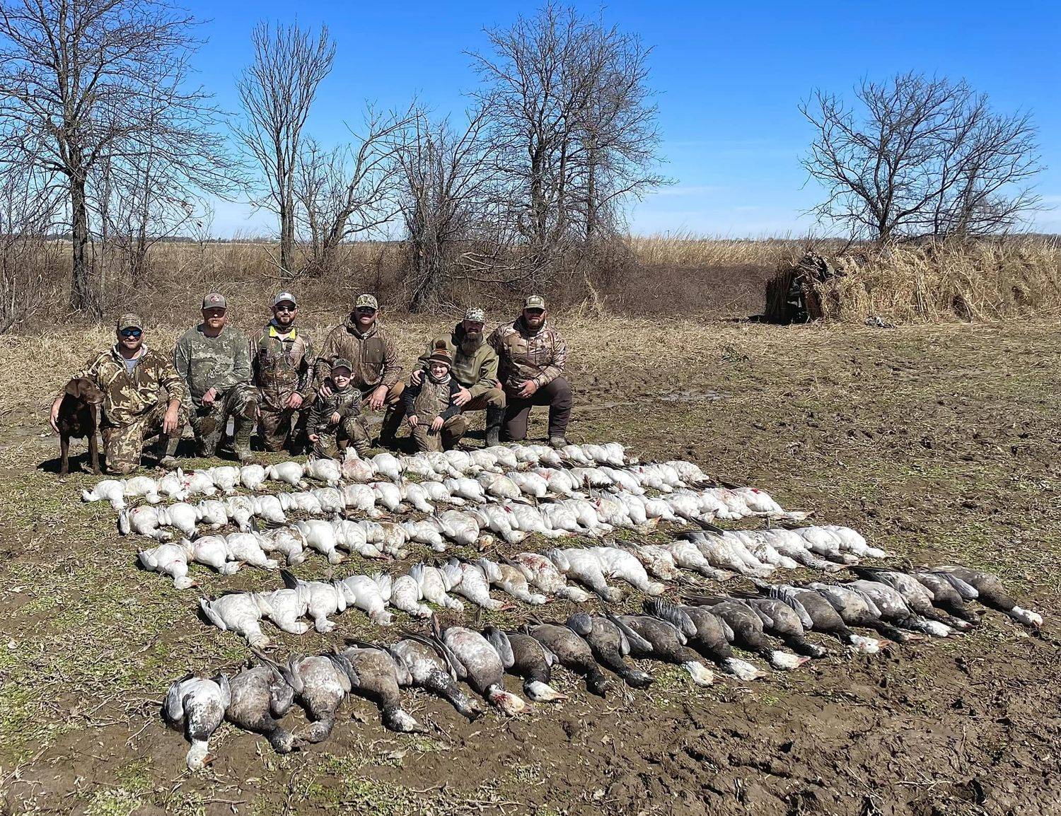 A NISKA group — kids included — behind rows of spring snow geese